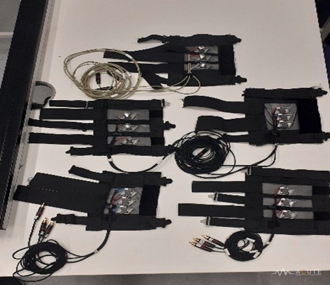Five VibroSleeve prototypes with different inter-actuator spacings arranged on a benchtop.